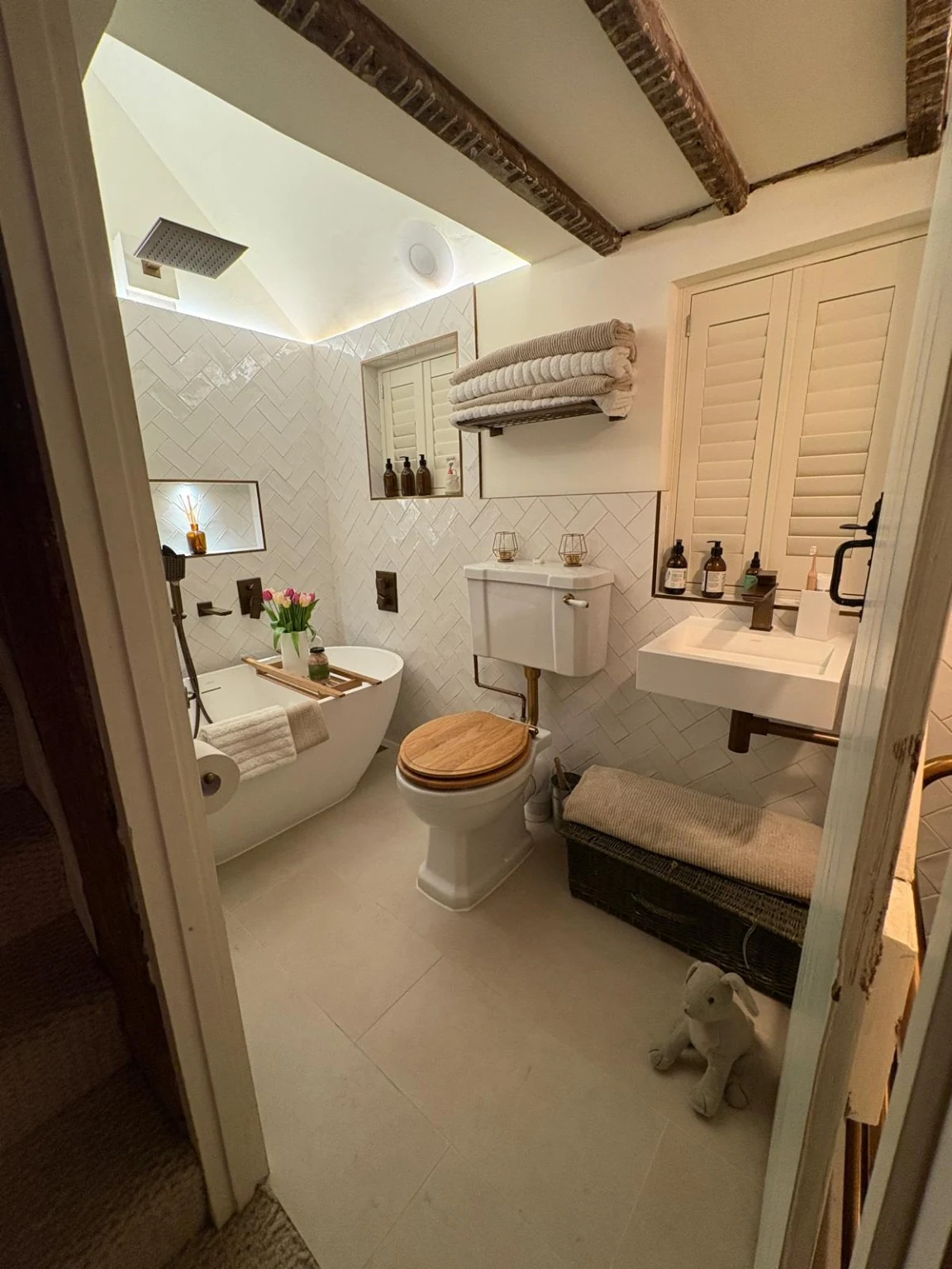 Completed bathroom viewed from the doorway, showing the raised ceiling above the bath and new lighting