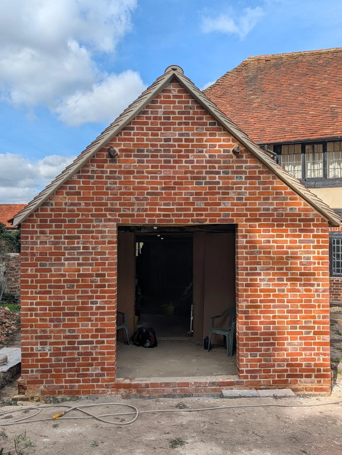 After the brickwork restoration: the rebuilt red-brick gable and new doorway opening beneath the tiled roof