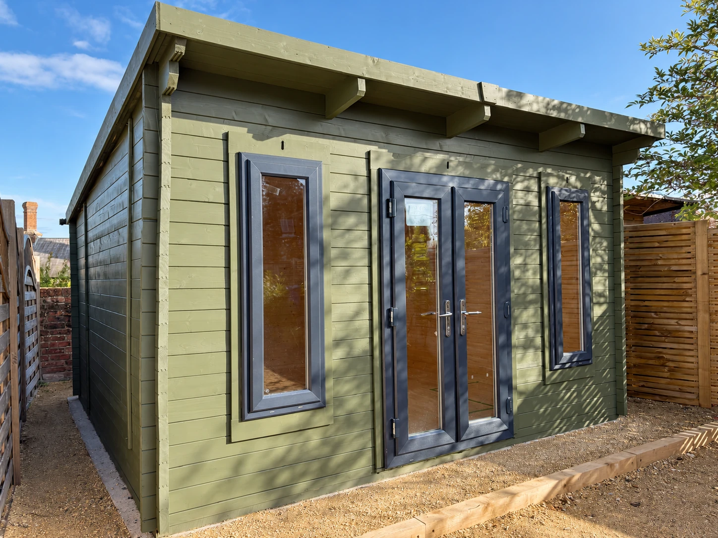 Angled view of the garden room showing the glazed front, left wall and roof overhang